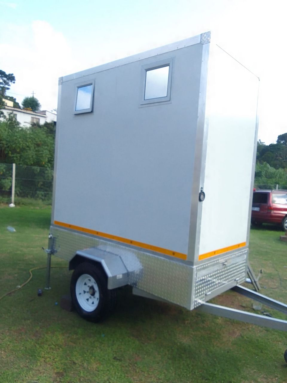 Side view of mobile toilet trailer with steel chassis